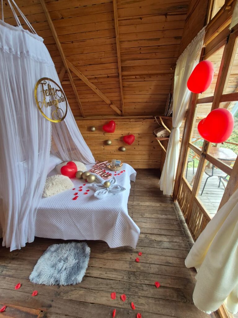 Cabaña decorada con pétalos y globos para una velada romántica